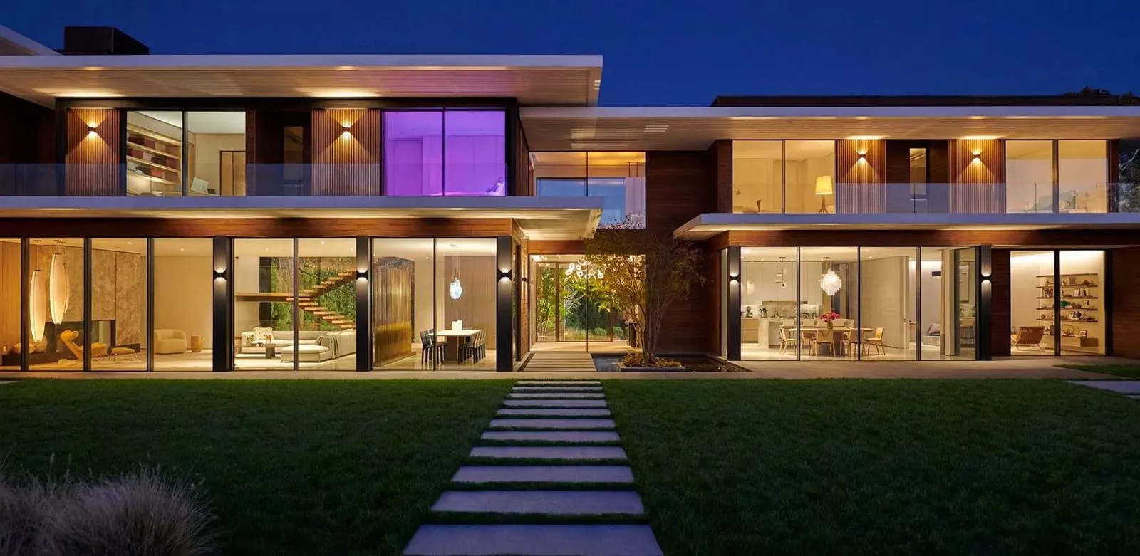 Modern house at dusk with every room lit in warm, balanced light